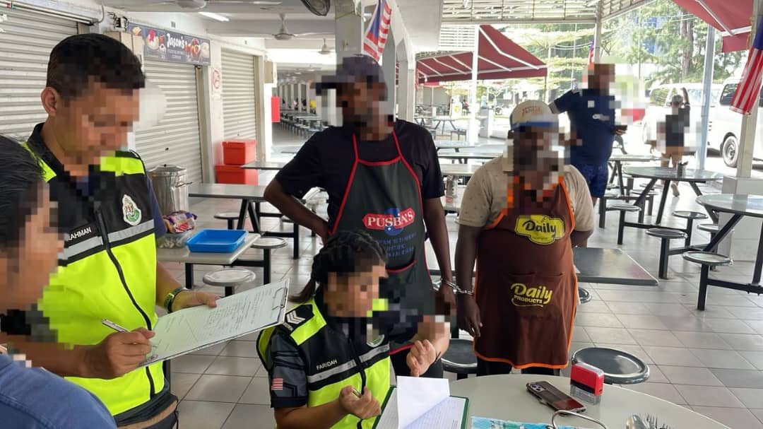 霹雳移民局官员检查食肆员工的逗留准证。（该局提供）