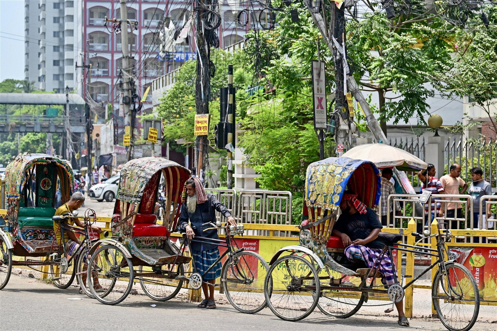 热浪周四继续袭击孟加拉国。在首都达卡，尽管酷热难耐，人力车车夫仍在街边等待乘客。（图取自法新社）