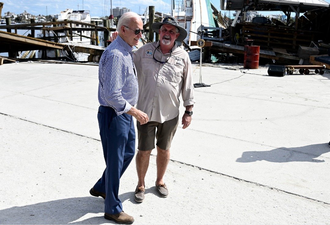 美国总统拜登（左）跟迈尔斯堡海滩市长墨菲（右）进行了似乎轻松愉快的交谈，但当时有麦克风没关，刚好录下他喷出“F”字眼。（图取自法新社）